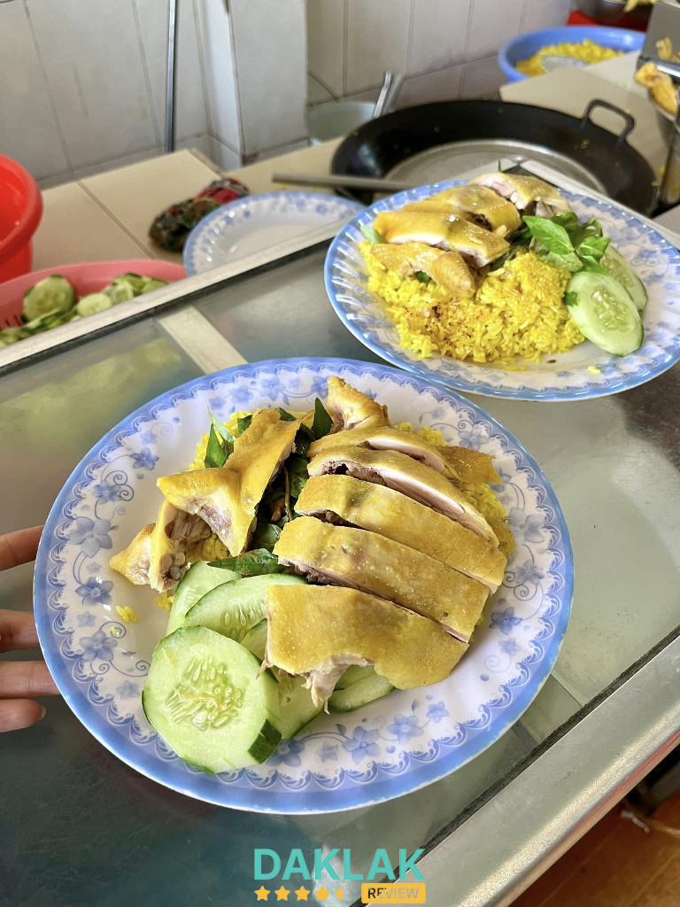 Cơm gà ta Thảo Nguyên 52 Ea Kar – cơm vàng, gà luộc chặt miếng, dưa leo ăn kèm.