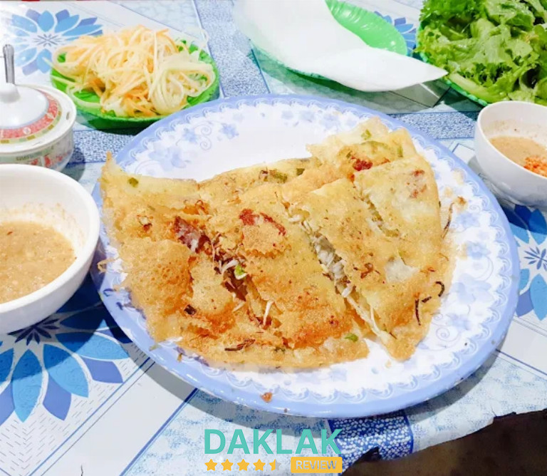 “Đĩa bánh xèo chảo Ea Kar vàng giòn, nhân tôm thịt, ăn kèm rau sống, đồ chua và chén nước chấm đặc trưng.”