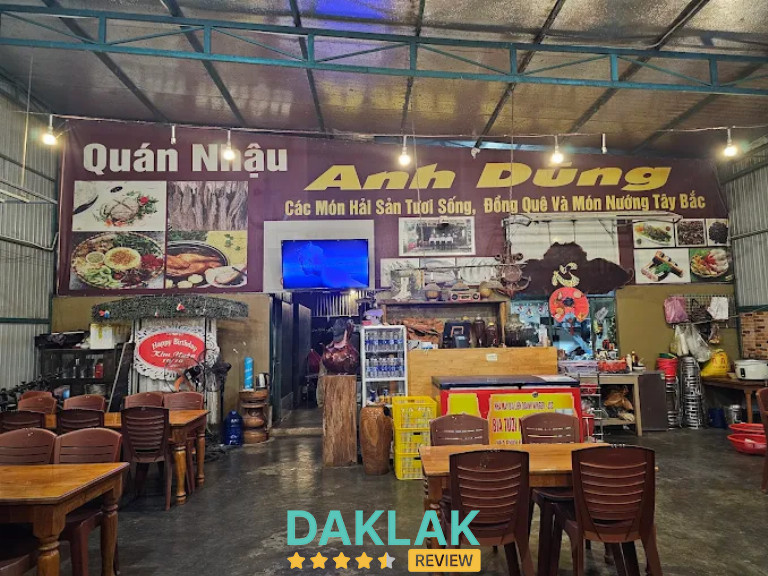“Không gian Quán Nhậu Anh Dũng Ea Kar với bàn ghế gỗ, quầy chế biến và bảng hiệu giới thiệu hải sản tươi sống, món đồng quê và nướng Tây Bắc.”