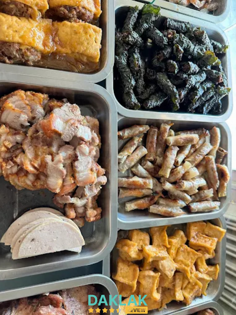 “Các khay đồ ăn tại Quán Cơm Trọng Hoan Ea Kar gồm thịt luộc, chả, nem, chả lá lốt và món chiên dọn sẵn cho khách chọn.”