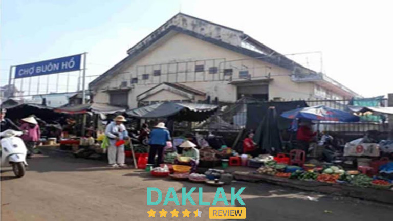 Chợ Buôn Hồ với các sạp rau củ và tiểu thương buôn bán ngoài sân chợ.