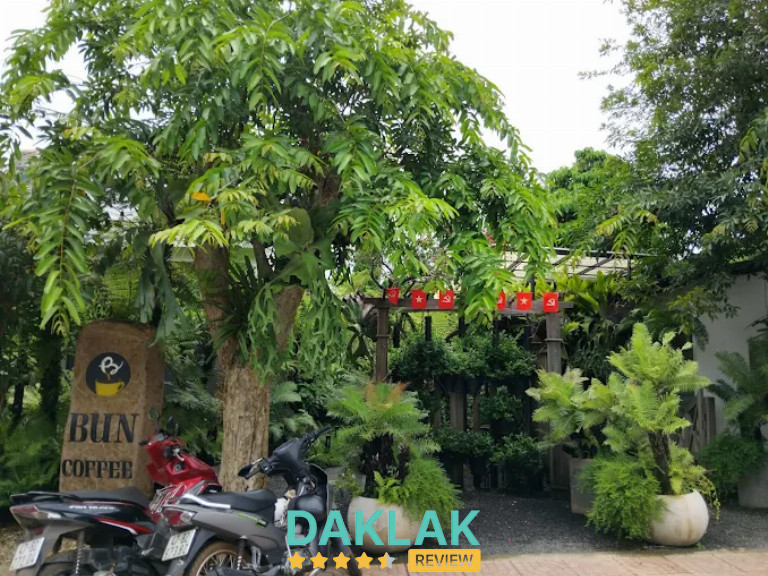 Bun coffee với bảng hiệu gỗ, nhiều cây xanh và không gian mộc mạc gần gũi