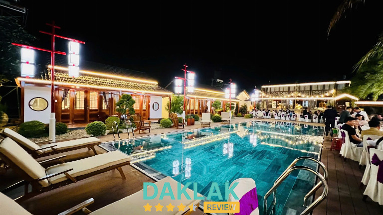 Hồ bơi tại Bazzan House Krông Bông về đêm với khu nhà gỗ sáng đèn và không gian tiệc đông vui