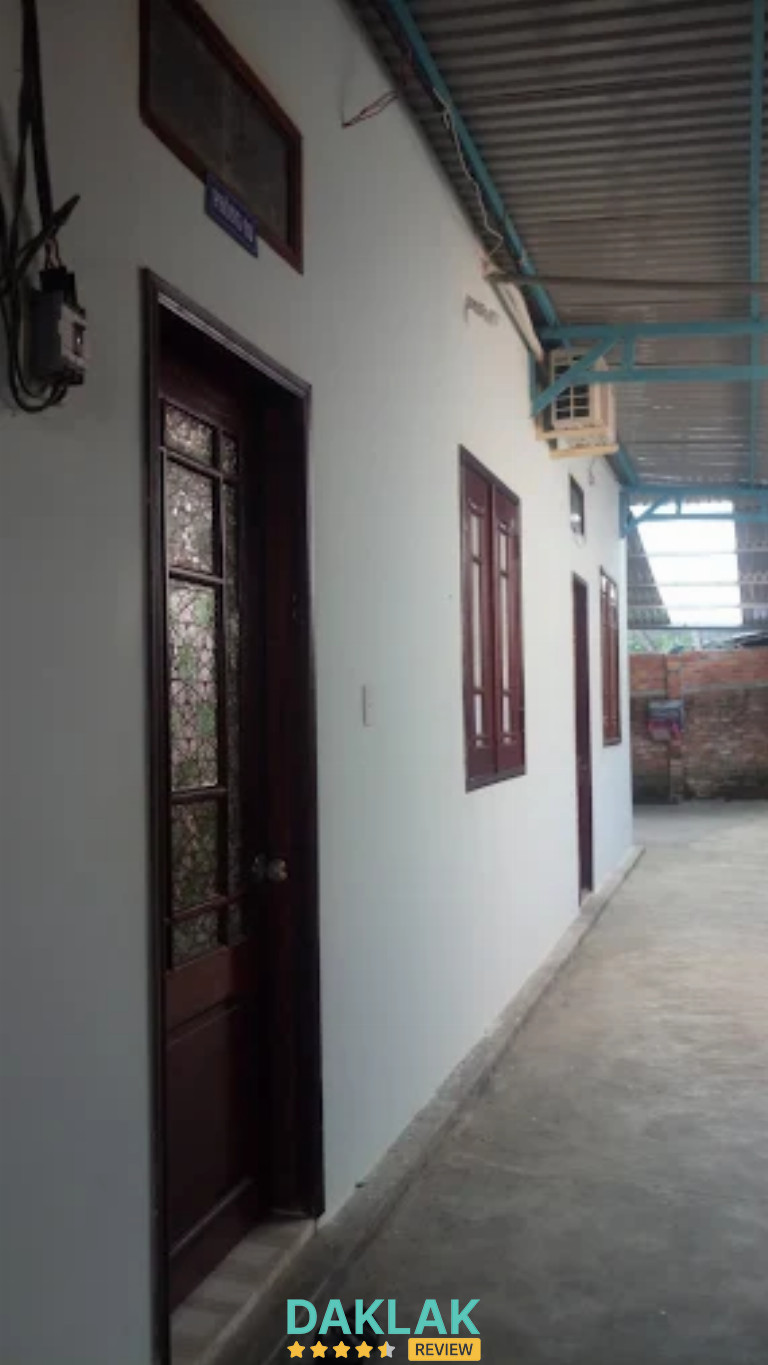 Hành lang nhà nghỉ Hương Rừng với các phòng liền kề, mái che và lối đi sạch sẽ"