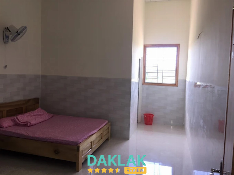 Phòng nghỉ nhà nghỉ Trà Giang có giường gỗ, cửa sổ lấy sáng và không gian thoáng