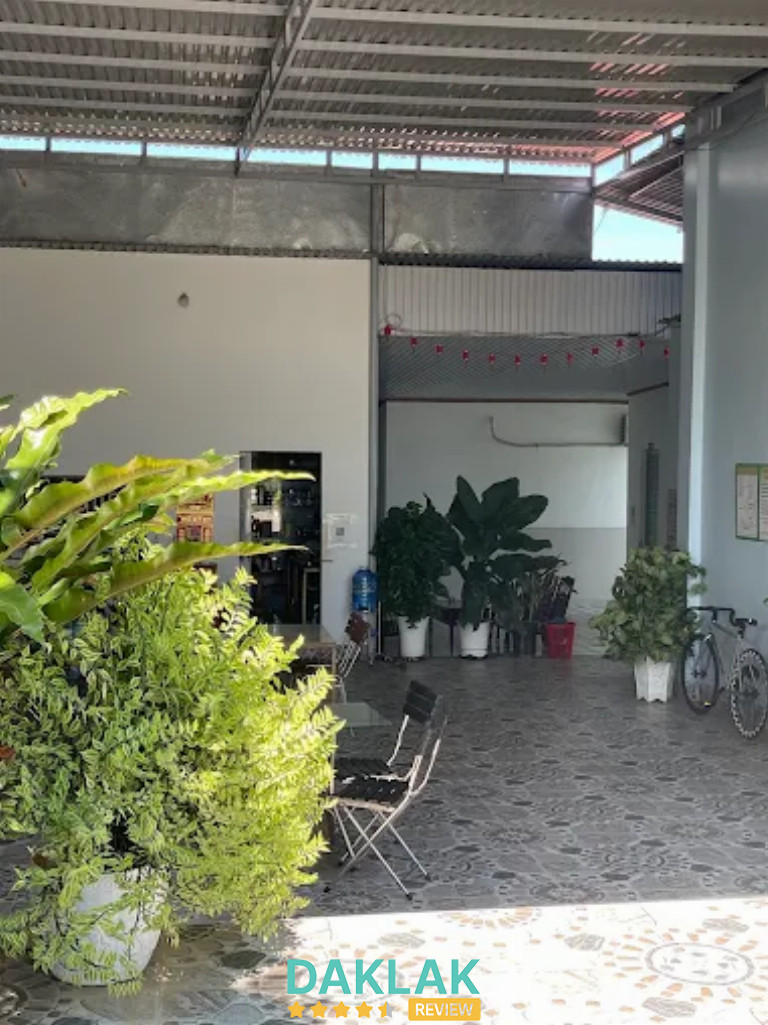 Khu sân trong nhà nghỉ 79 với nhiều cây xanh, bàn ghế và không gian thoáng