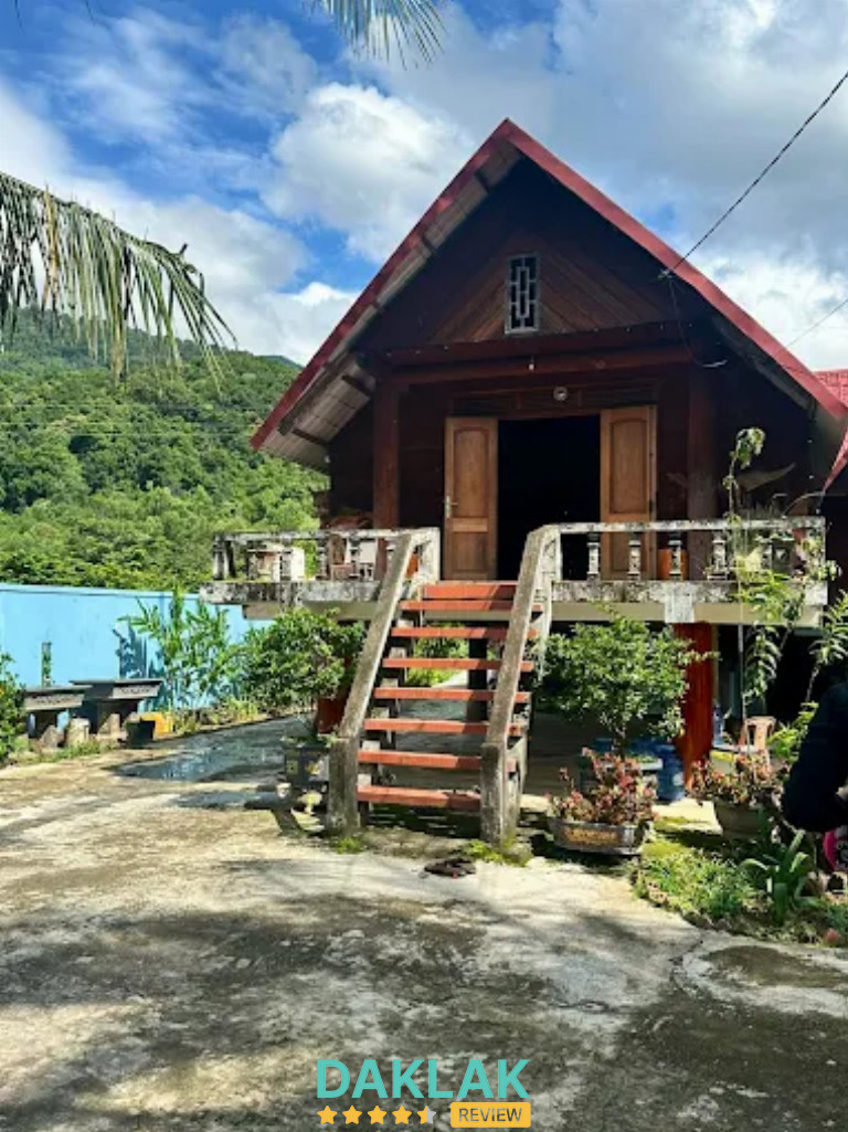 Nhà gỗ nhà nghỉ Chân Đồi nằm dưới chân đồi, có cầu thang gỗ và cây xanh xung quan