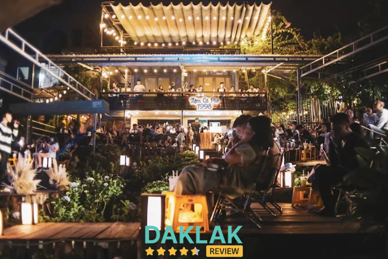 “Không gian Tiệm Cafe 1998 Buôn Ma Thuột buổi tối với khu sân vườn đông khách và ánh đèn trang trí”