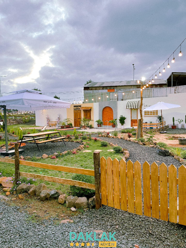 “Khuôn viên Mộc Garden Buôn Ma Thuột với lối đi sỏi, tiểu cảnh và khu chụp hình ngoài trời”
