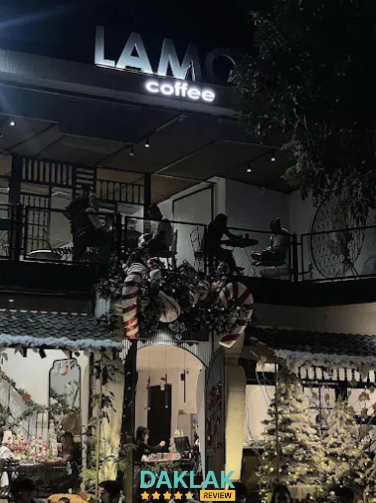 “Không gian bên ngoài Là Mơ Coffee Buôn Ma Thuột buổi tối với tầng ngồi trên cao và trang trí Noel phía trước quán”