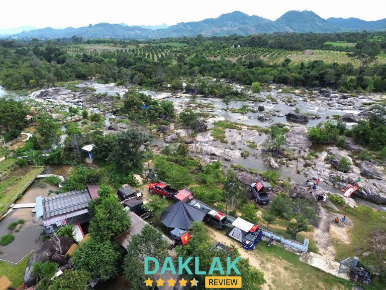 Toàn cảnh thác Krông Kmar nhìn từ Hội quán Suối Thanh Niên với đá lớn, dòng suối và núi Chư Yang Sin