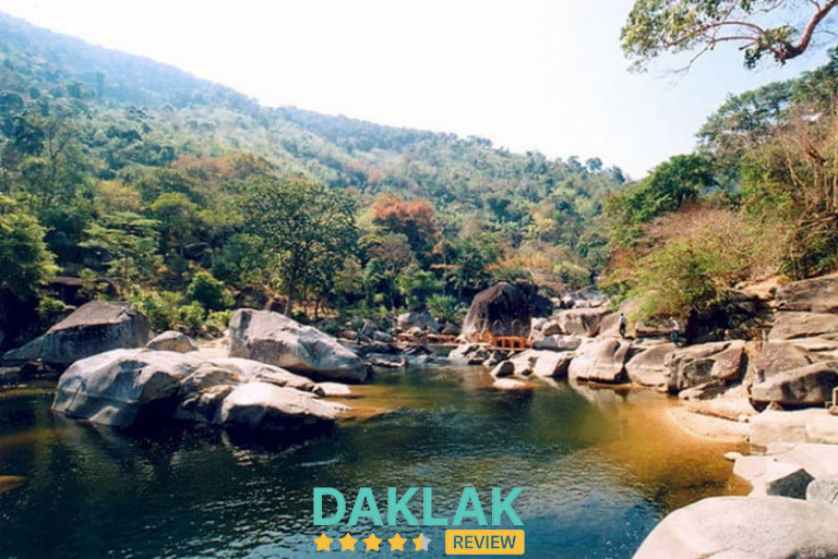 Dòng suối Krông Kmar chảy nhẹ giữa những tảng đá lớn, nước trong và không gian rừng núi mát lạnh